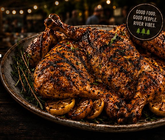 A platter of grilled FlatBird chicken with charred lemons